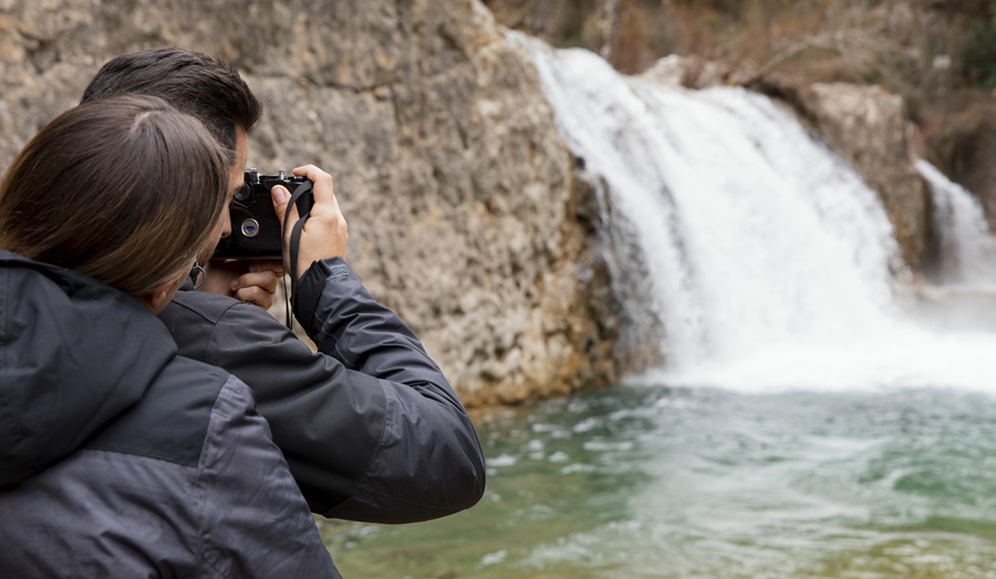 coppia che fa una fotografia ad una cascata